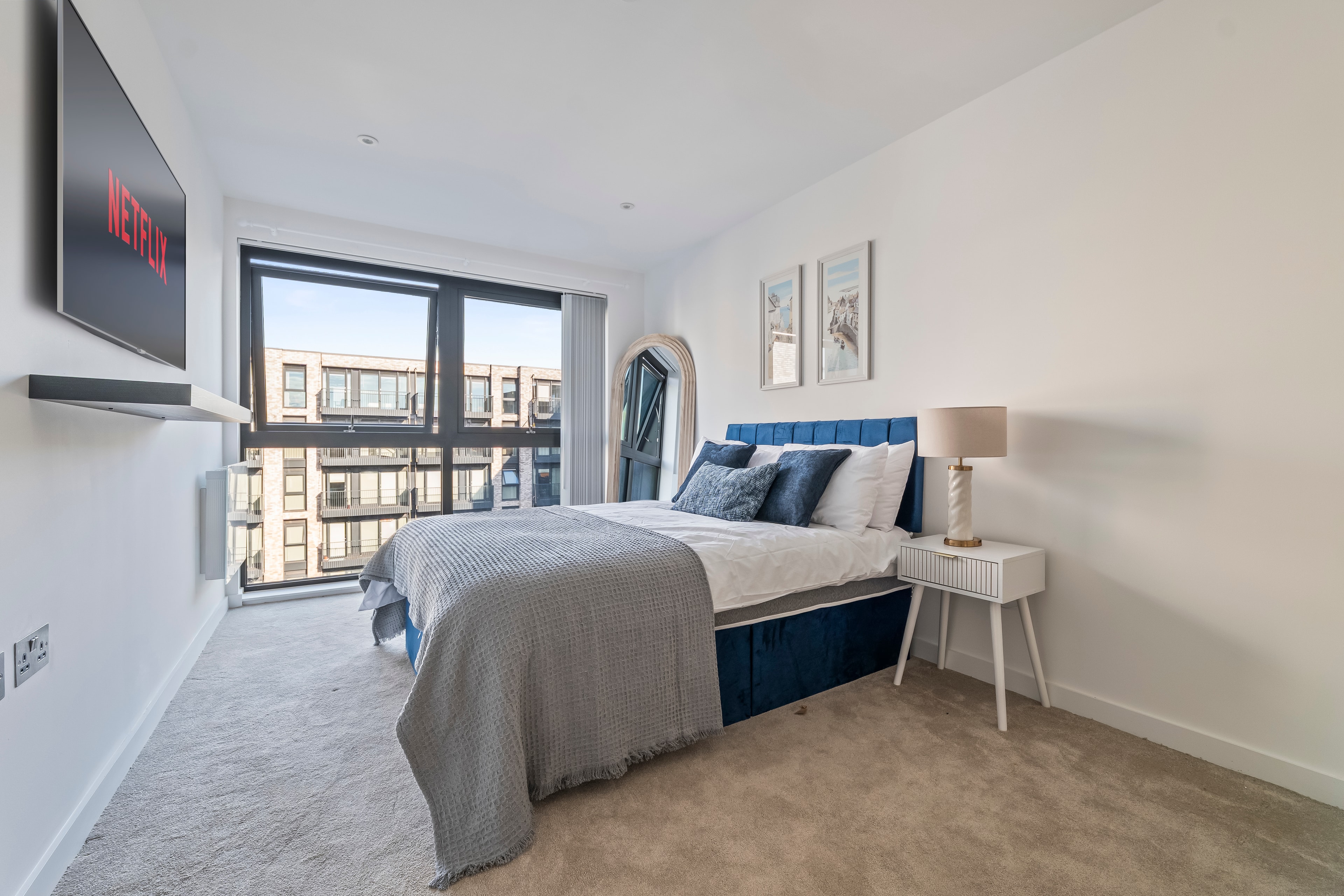 Second bedroom with blue velvet bed and city views